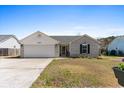 Well-maintained single-story home featuring brick accents, an attached garage, and a lush front lawn under a clear sky at 620 Charter Dr., Longs, SC 29568