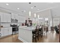 Bright, modern kitchen featuring white cabinets, stainless steel appliances, and a large island with seating at 800 Lorenzo Dr., North Myrtle Beach, SC 29582