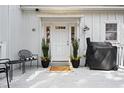 Inviting front porch with seating area and a modern grill at 81 Woodpecker Ln., Pawleys Island, SC 29585