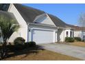 Charming home with vinyl siding, an attached garage, driveway, and well-manicured landscaping at 1307 Chelsea Ln., Longs, SC 29568