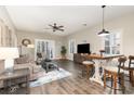 Cozy living room features stylish furnishings, ceiling fan, wood floors, and ample natural light at 2060 Cross Gate Blvd. # 104, Surfside Beach, SC 29575