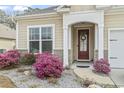 Inviting home entrance with a red front door, decorative wreath, and manicured landscaping at 275 Castaway Key Dr., Pawleys Island, SC 29585