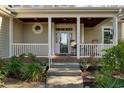 Close up of the home's covered front porch with wood ceiling, tile steps, and decorative front door at 4966 S Island Dr. S, North Myrtle Beach, SC 29582