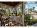 Cozy covered front porch with seating provides a tranquil outdoor space with views of the surrounding yard at 4966 S Island Dr. S, North Myrtle Beach, SC 29582