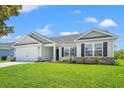 Inviting exterior showcasing a well-maintained lawn, attached garage, and attractive architectural details at 632 Woodside Dr., Conway, SC 29526