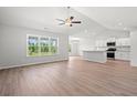 Bright living room featuring hardwood floors, large windows, and an open layout to the kitchen area at 632 Woodside Dr., Conway, SC 29526
