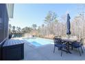 Inviting backyard pool area with patio, dining set, and serene wooded backdrop, creating a private outdoor retreat at 780 Old Murrells Inlet Rd., Murrells Inlet, SC 29576