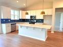 Bright kitchen with white cabinets, an island, stainless appliances, and stylish blue backsplash at 8628 Farrier Dr., Myrtle Beach, SC 29588