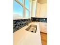 Close-up of a kitchen sink with quartz countertops and a blue tile backsplash at 8628 Farrier Dr., Myrtle Beach, SC 29588