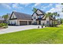 Beautiful home with a lush green lawn, manicured garden beds, and a spacious concrete driveway and three car garage at 9785 Anchor Dr., Longs, SC 29568