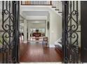Inviting foyer with hardwood floors, wrought iron door, staircase, and open view to a cozy sitting room at 9785 Anchor Dr., Longs, SC 29568