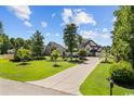 Expansive front yard and landscaped lawn leads to a brick two story home and large driveway at 9785 Anchor Dr., Longs, SC 29568