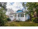Angle view of a charming blue house with a welcoming front porch and mature trees at 1019 Prince St., Georgetown, SC 29440