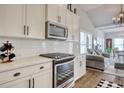 Modern kitchen boasts white cabinets, stainless steel appliances, and a view into the living room with vaulted ceilings at 1439 Castleberry Pl., Myrtle Beach, SC 29588