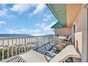 Outdoor seating and lounge furniture on a covered balcony with ocean views at 145 South Dunes Dr. # 503, Pawleys Island, SC 29585