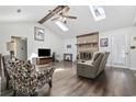 Open living room with vaulted ceilings, skylights, wood beams, brick fireplace, hardwood floors, and comfortable seating at 1463 Gibson Ave., Surfside Beach, SC 29575