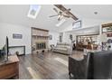 Bright living room featuring vaulted ceilings, exposed wood beams, brick fireplace, hardwood floors, and multiple skylights at 1463 Gibson Ave., Surfside Beach, SC 29575