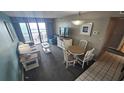 A view of the living room showing sliding glass doors to the exterior and a small dining room at 2701 N Ocean Blvd. # 1561-64, Myrtle Beach, SC 29577
