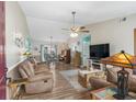 A well-lit living room with comfortable brown furniture, wood floors, and an open dining area at 2759 Temperance Dr., Myrtle Beach, SC 29577
