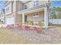 Charming front porch with decorative plants and chairs, leading to the home's entrance at 404 Cattle Drive Circle, Myrtle Beach, SC 29588