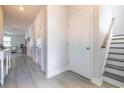 Bright hallway with neutral paint, wood-look floors, and access to stairs and other rooms at 404 Cattle Drive Circle, Myrtle Beach, SC 29588