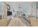Bright living room with vaulted ceilings, wood floors, stylish furniture, and beach-themed decor at 414 S Dogwood Dr., Garden City Beach, SC 29576