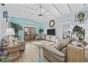 Spacious living room featuring vaulted ceilings, wood floors, modern decor, and a ceiling fan at 414 S Dogwood Dr., Garden City Beach, SC 29576