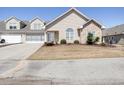 Attractive home featuring stone accents, a well-manicured lawn, neutral siding, and an attached garage at 4243 Rivergate Ln., Little River, SC 29566