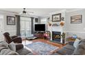 Cozy living room featuring hardwood floors, a decorative fireplace, and a large window with natural light at 450 Deer Spring Loop, Georgetown, SC 29440