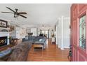 Bright living room with hardwood floors, gray sofa, a fireplace, and open layout with seamless flow to the kitchen at 450 Deer Spring Loop, Georgetown, SC 29440