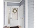 Charming entryway with white door, glass panel, wreath, welcome mat and light blue siding at 4637 Lightkeepers Way # 4-A, Little River, SC 29566