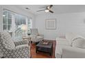 Bright and airy living room with hardwood floors, ceiling fan, two decorative armchairs, and a comfortable sofa at 4637 Lightkeepers Way # 4-A, Little River, SC 29566