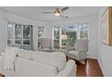 Bright living room with hardwood floors, large windows, two decorative armchairs, and a comfortable sofa at 4637 Lightkeepers Way # 4-A, Little River, SC 29566