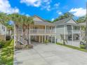 Stilt home with a large parking area, a front porch, and tropical landscaping at 511 N 21St Ave. N, North Myrtle Beach, SC 29582