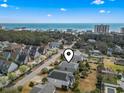 Aerial view of beach neighborhood featuring coastal homes, tree-lined street, and the ocean in the background at 619 10Th Ave. S, North Myrtle Beach, SC 29582