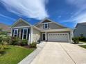 Charming home exterior with neutral siding, rocking chairs on the porch, and a two-car garage at 808 Yauhannah Dr., Little River, SC 29566