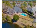 Aerial view of the property featuring a pool, hot tub, fenced yard and lake at 915 Preservation Circle, Pawleys Island, SC 29585