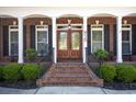 Charming front porch with brick steps, black shutters, double doors and well maintained landscaping at 915 Preservation Circle, Pawleys Island, SC 29585