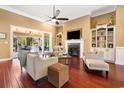 Open concept living room featuring hardwood floors, a fireplace, built-in shelving, and access to the porch at 915 Preservation Circle, Pawleys Island, SC 29585