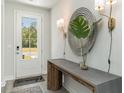 Inviting foyer with console table, decorative mirror, stylish lighting, and view of front yard through the door at 918 Belle Dr., North Myrtle Beach, SC 29582