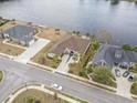 Expansive aerial view of a waterfront home with a brick drive and walkway, lush landscaping, and scenic surroundings at 1012 Dowitcher Dr., Conway, SC 29526