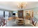 Elegant dining room featuring a glass table, ornate chandelier, and built-in china cabinet with ocean views at 10200 Beach Club Dr. # 6B, Myrtle Beach, SC 29572
