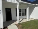 Close-up of the front entrance, showcasing the black door, white columns, house number, and a glimpse of the front lawn at 10534 W Highway 19, Loris, SC 29569