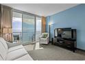 Comfortable living room with direct access to a private balcony offering views of the ocean at 107 S Ocean Blvd. # 2106, Myrtle Beach, SC 29577
