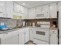 Well-lit kitchen with white cabinetry and backsplash, offering modern appliances and functionality at 1210 N Waccamaw Dr. # 1105, Murrells Inlet, SC 29576
