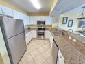 Bright kitchen with white cabinets, stainless steel appliances, and granite countertops with bar seating at 2007 S Ocean Blvd. # 204, Myrtle Beach, SC 29577