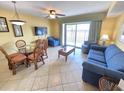 Inviting living room features tile floors, a ceiling fan, comfortable seating, and a glass door to a balcony at 2007 S Ocean Blvd. # 204, Myrtle Beach, SC 29577