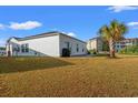 Expansive backyard featuring lush grass, a palm tree, and a view of nearby condominiums at 2015 Borgata Loop, Longs, SC 29568