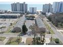 Aerial view of townhomes near the beach with a parking lot and palm trees, offering a serene coastal setting at 210 25Th Ave. S # 26, Myrtle Beach, SC 29577