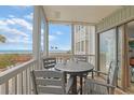 View from the balcony of the ocean, pool, and other condos and an outdoor table and chairs at 2405 S Ocean Blvd. # 105, North Myrtle Beach, SC 29582